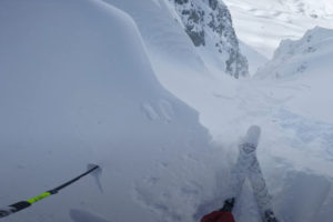 A POV of a skier about to drop into an intense line