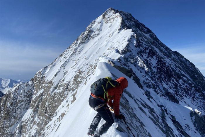 a mountaineer on a summit ridgeline