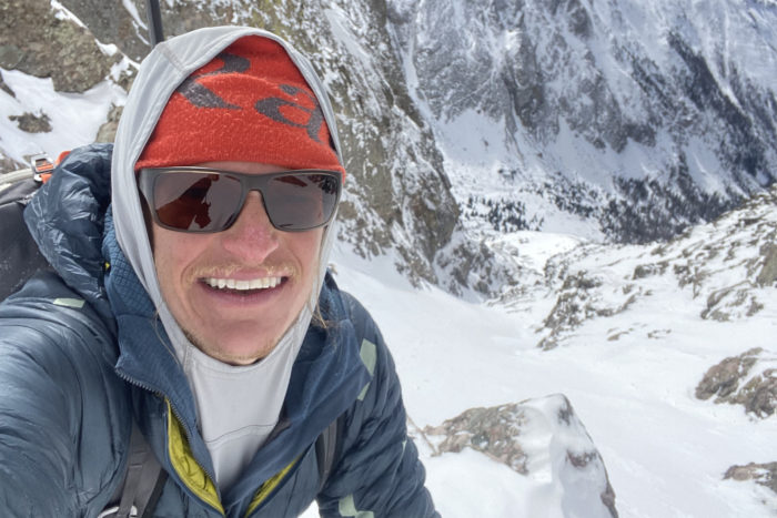 Chris Fisher takes a selfie on a mountain peak. 