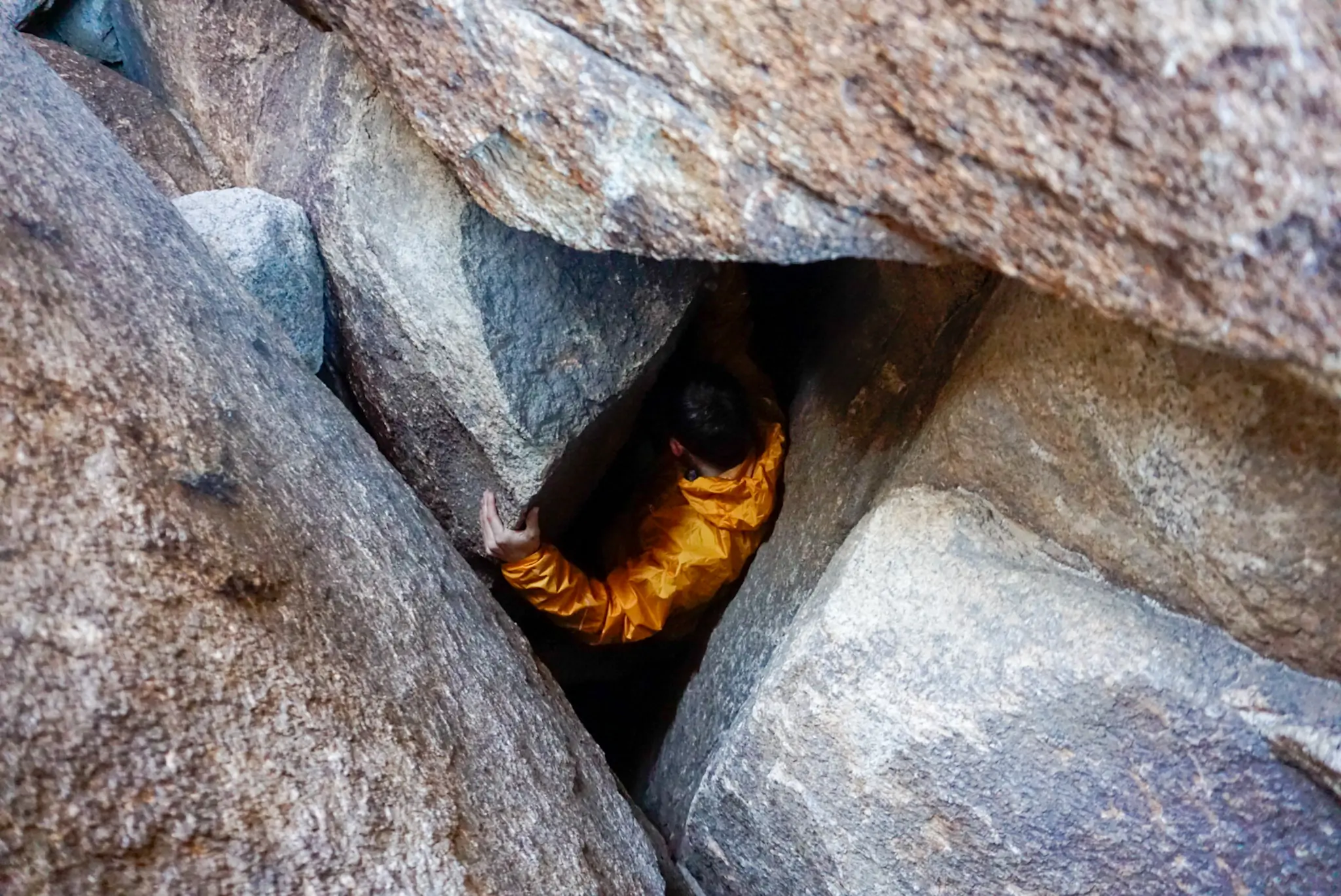 Outdoor Research Helium Rain Jacket Stress Test A Climber Descends Into a Hole in the Rock Wearing the Outdoor Research Helium Rain Jacket
