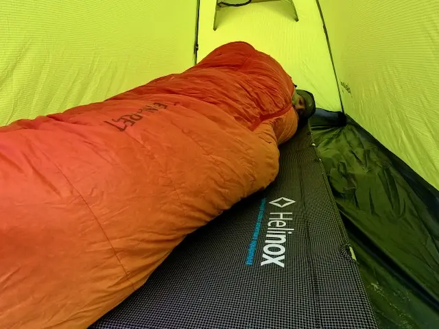Camper Laying On Top of the Helinox Lite Cot Inside Tent