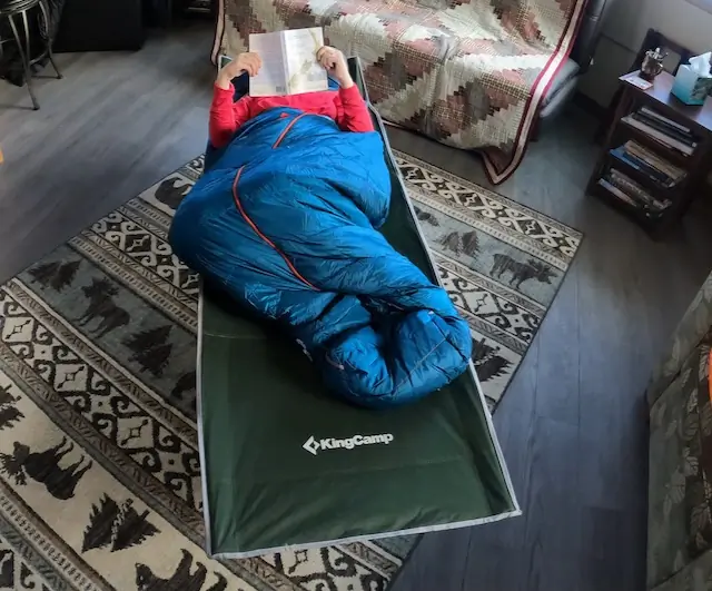 Woman Reading on the King Camp Folding Cot Inside Cabin