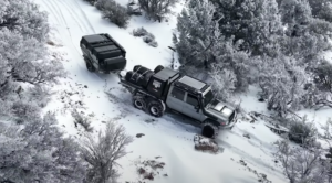 A six-wheel-drive Toyota Land Cruiser towing a trailer through snow