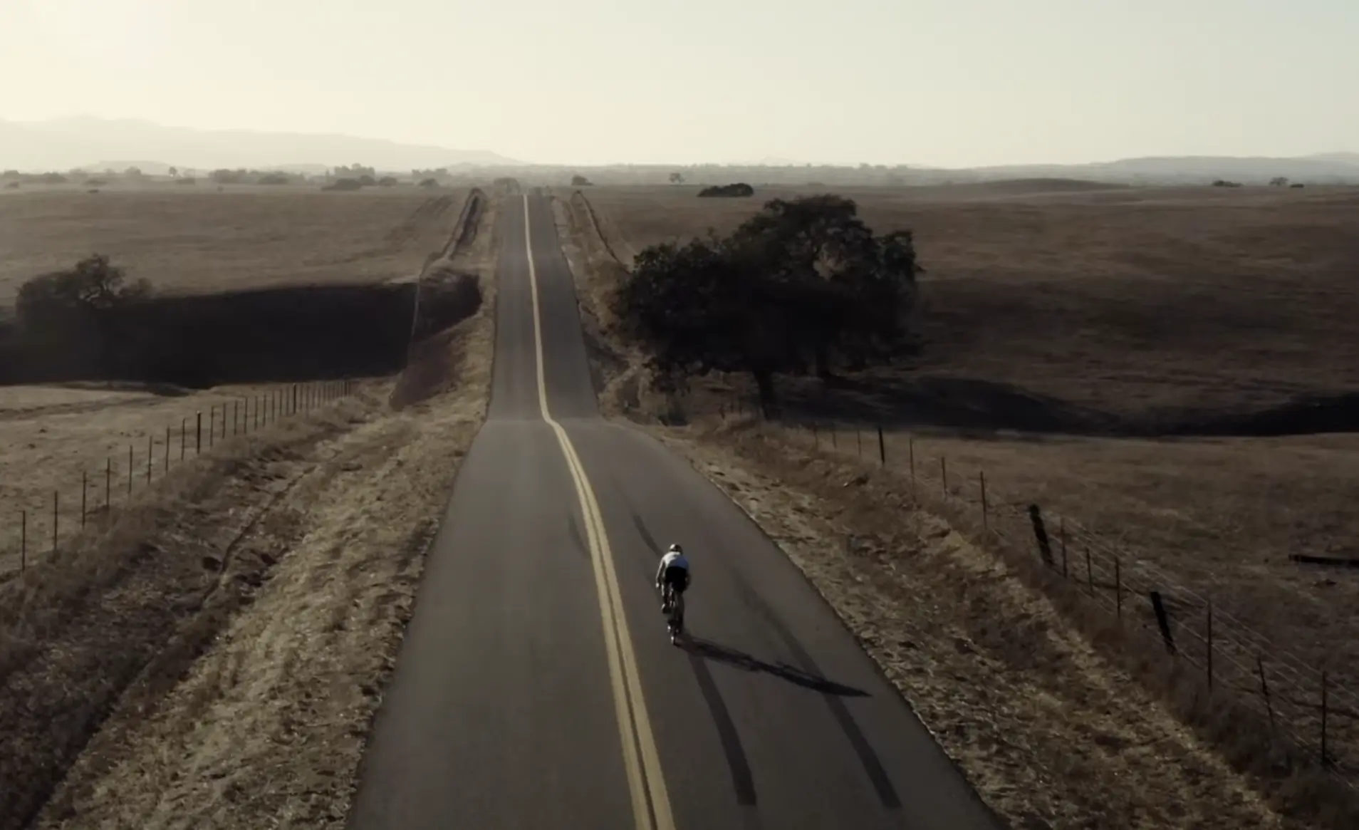 a cyclist pedals down a lonely highway