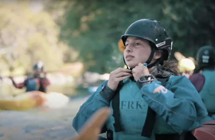 A woman paddler straps on her helmet