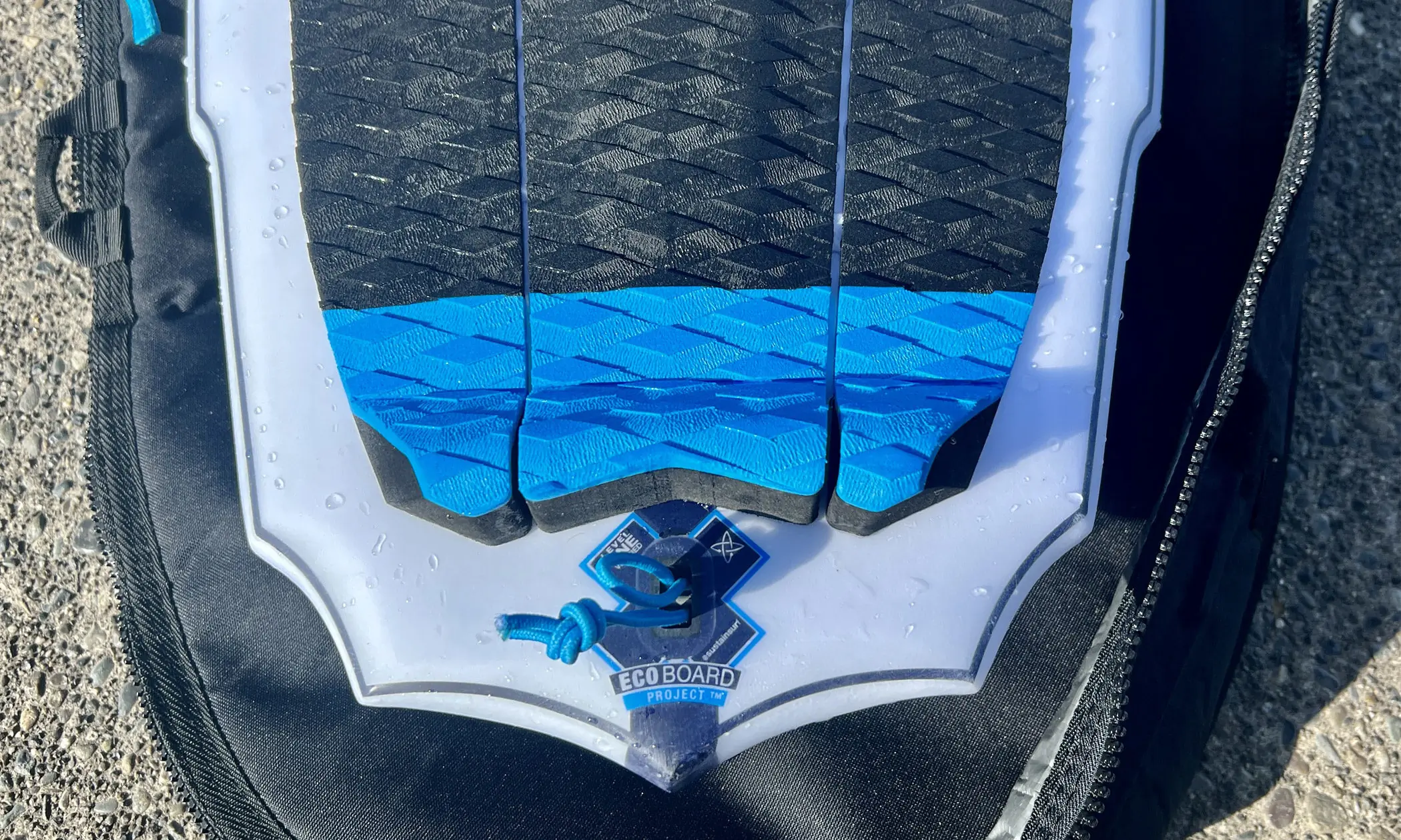 Slater Designs Sci-Fi 2.0 surfboard on bag on dock closeup of ECOBOARD branding