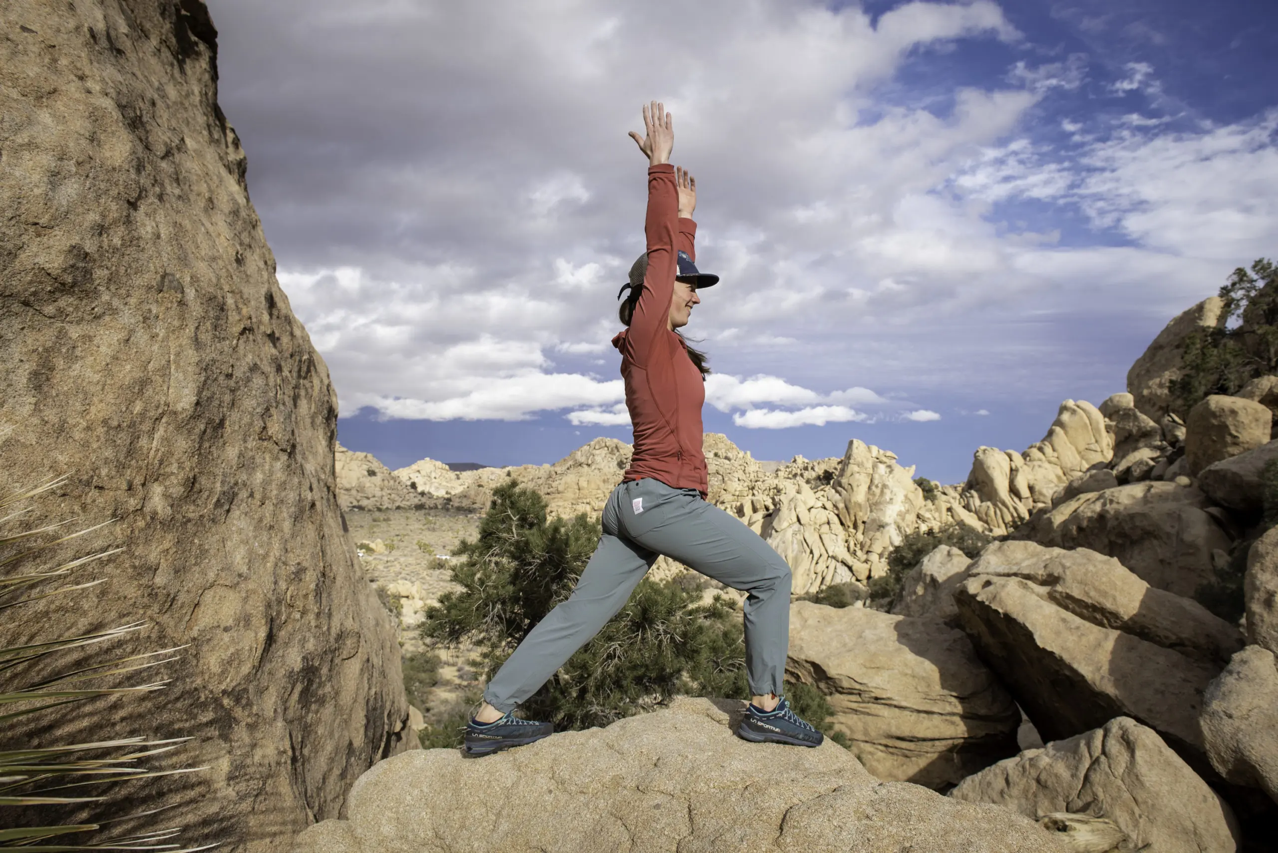 A Climber Stretches in Joshua Tree National Park Wearing the Topo Designs Women's Boulder Pants