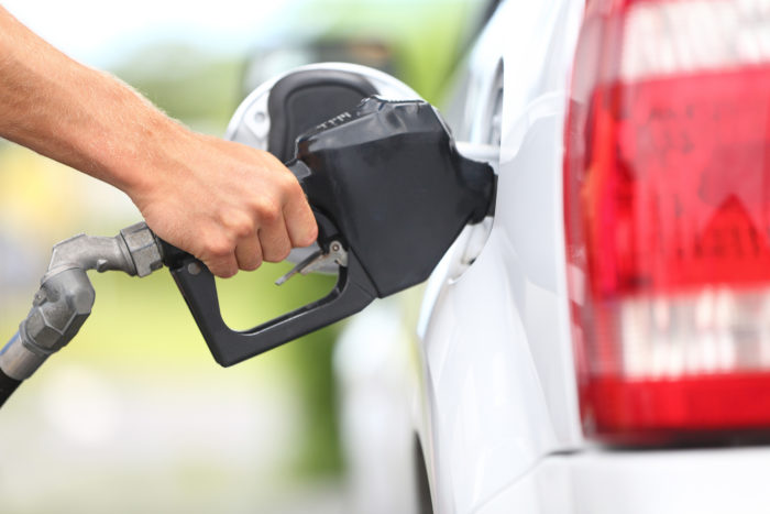 a hand pumping gas at a gas station