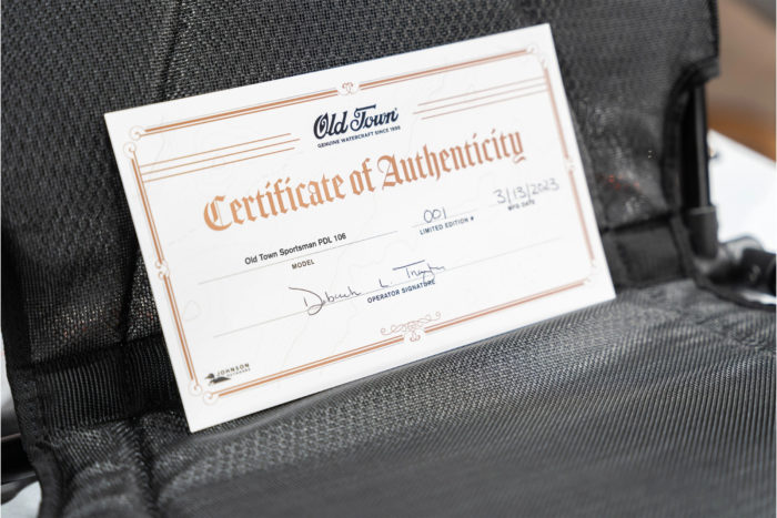 an Old Town certificate of authenticity propped up against a seat inside a boat