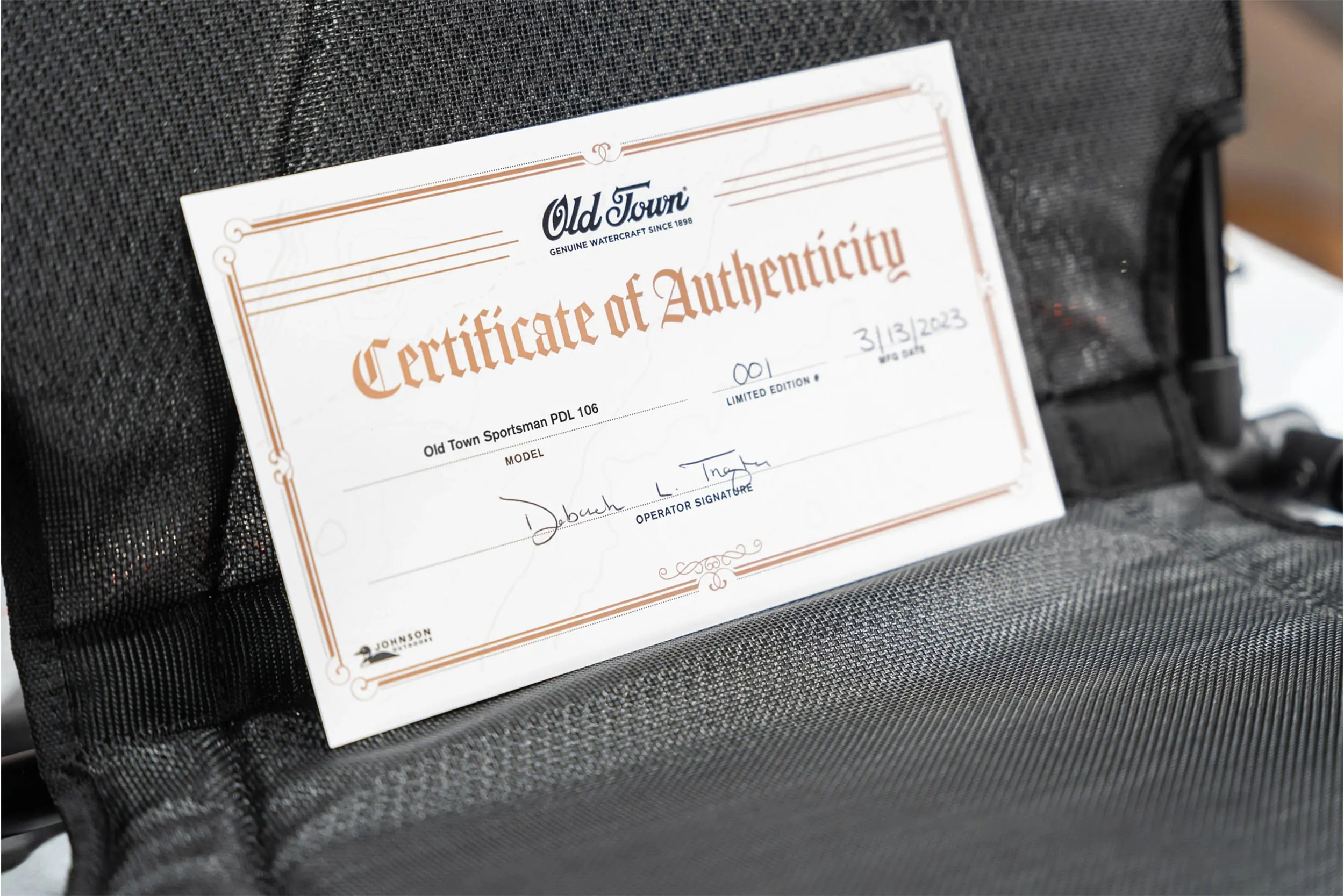 an Old Town certificate of authenticity propped up against a seat inside a boat