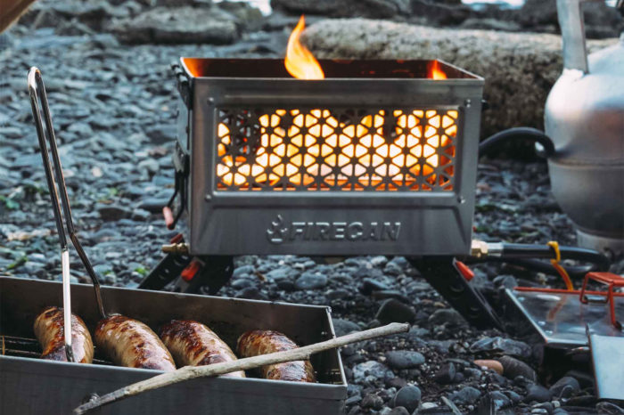 brats cooking in firecan deluxe on rocky beach