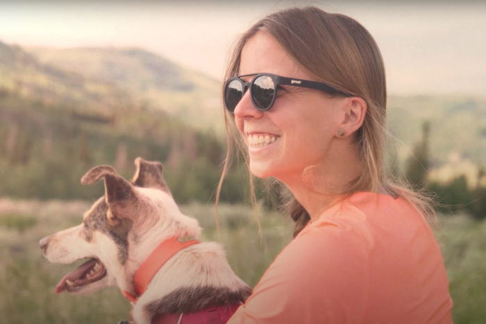 Keely Henninger sits with her dog in front of a mountain view