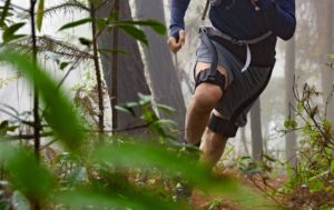 Man running through the woods wearing a Hypershell