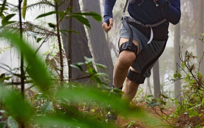 Man running through the woods wearing a Hypershell