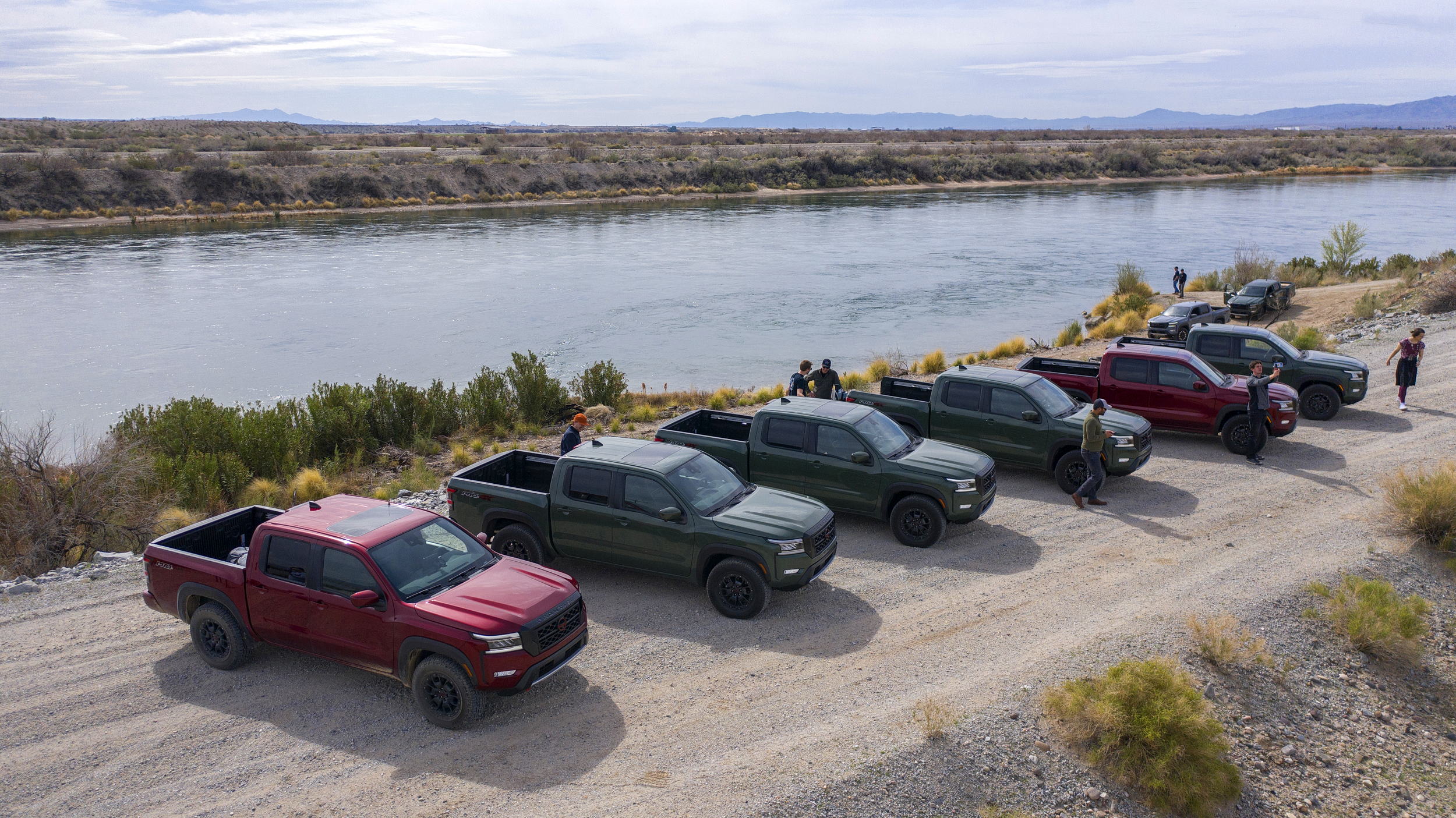 Nissan Frontier pickup trucks lined up on the banks of Colorado River