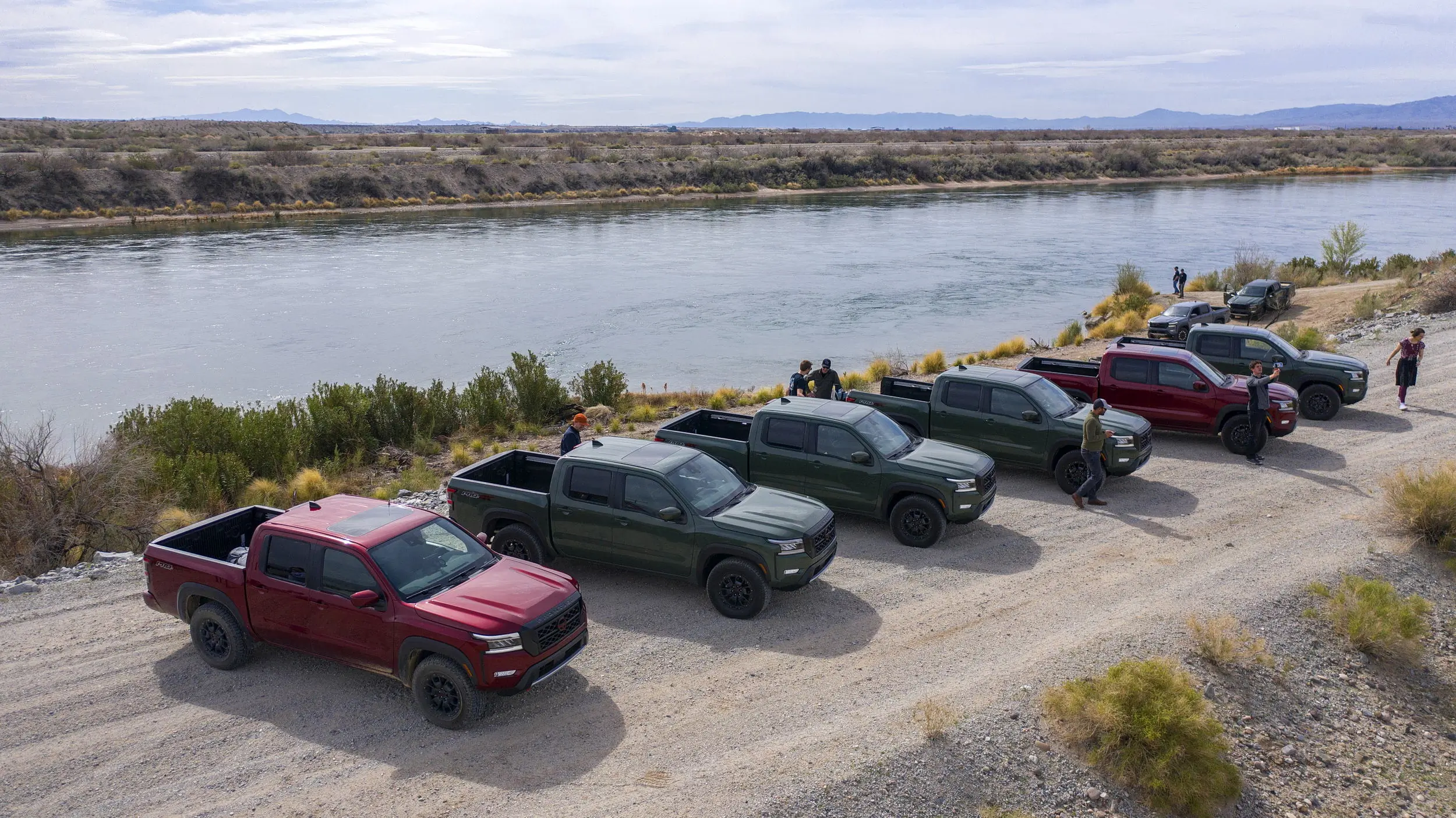 Nissan Frontier pickup trucks lined up on the banks of Colorado River