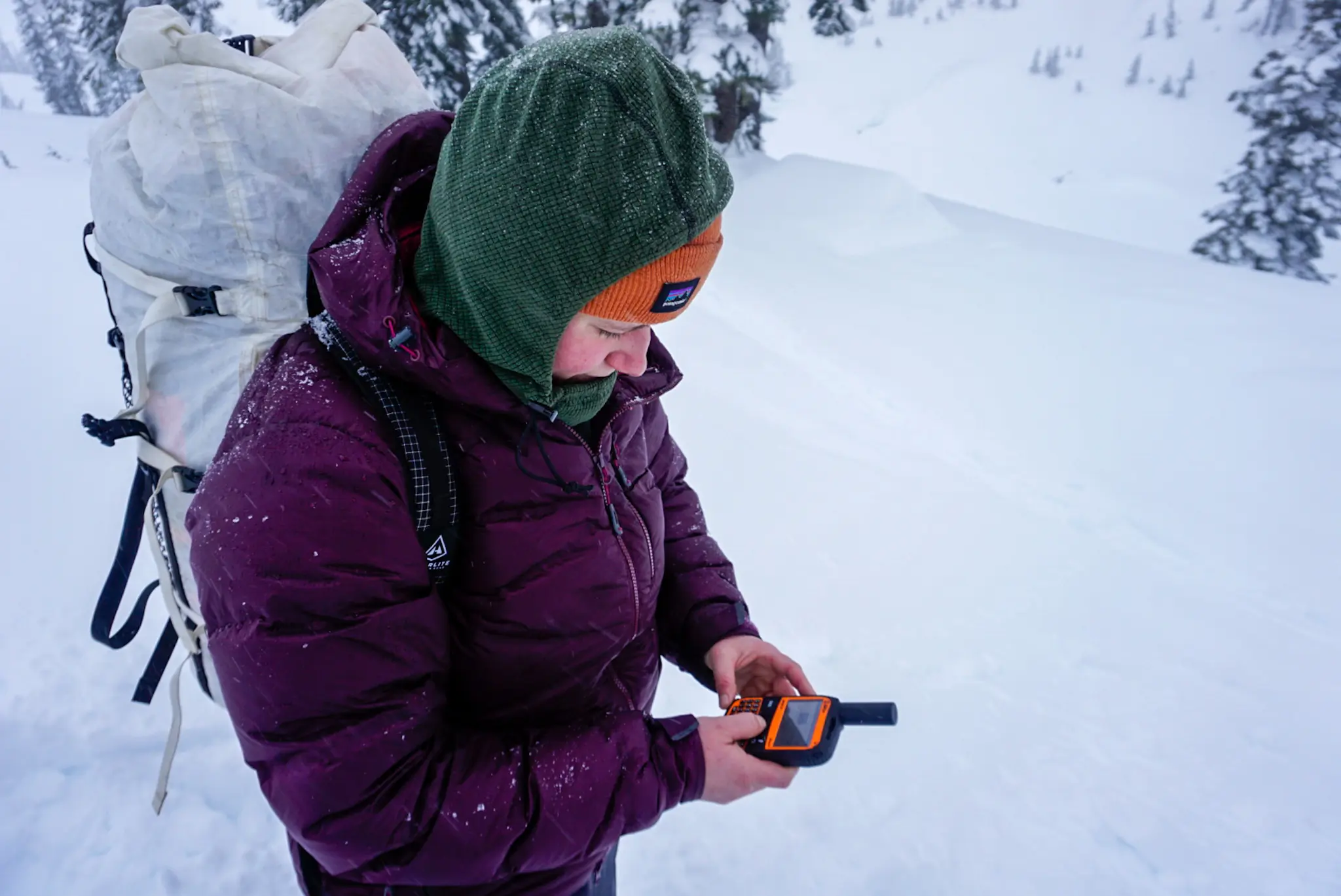 A Hiker Holds The SPOT X Messenger While Navigating in Snow