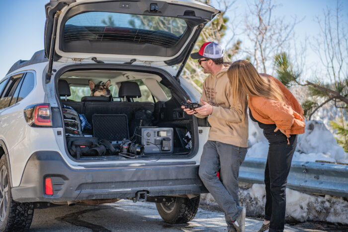 two people charging their stuff out of their suburu on a BLUETTI power station