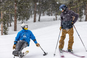 author aaron bible skis with sit-skier trevor kennison in Winter Park, colo.