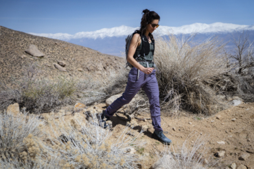 A woman walks through the desert while wearing women's hiking pants