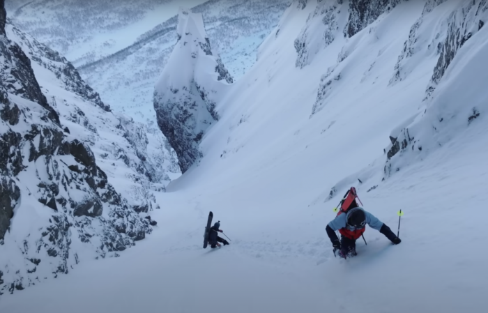 skiers climb a couloir with crampons and axes