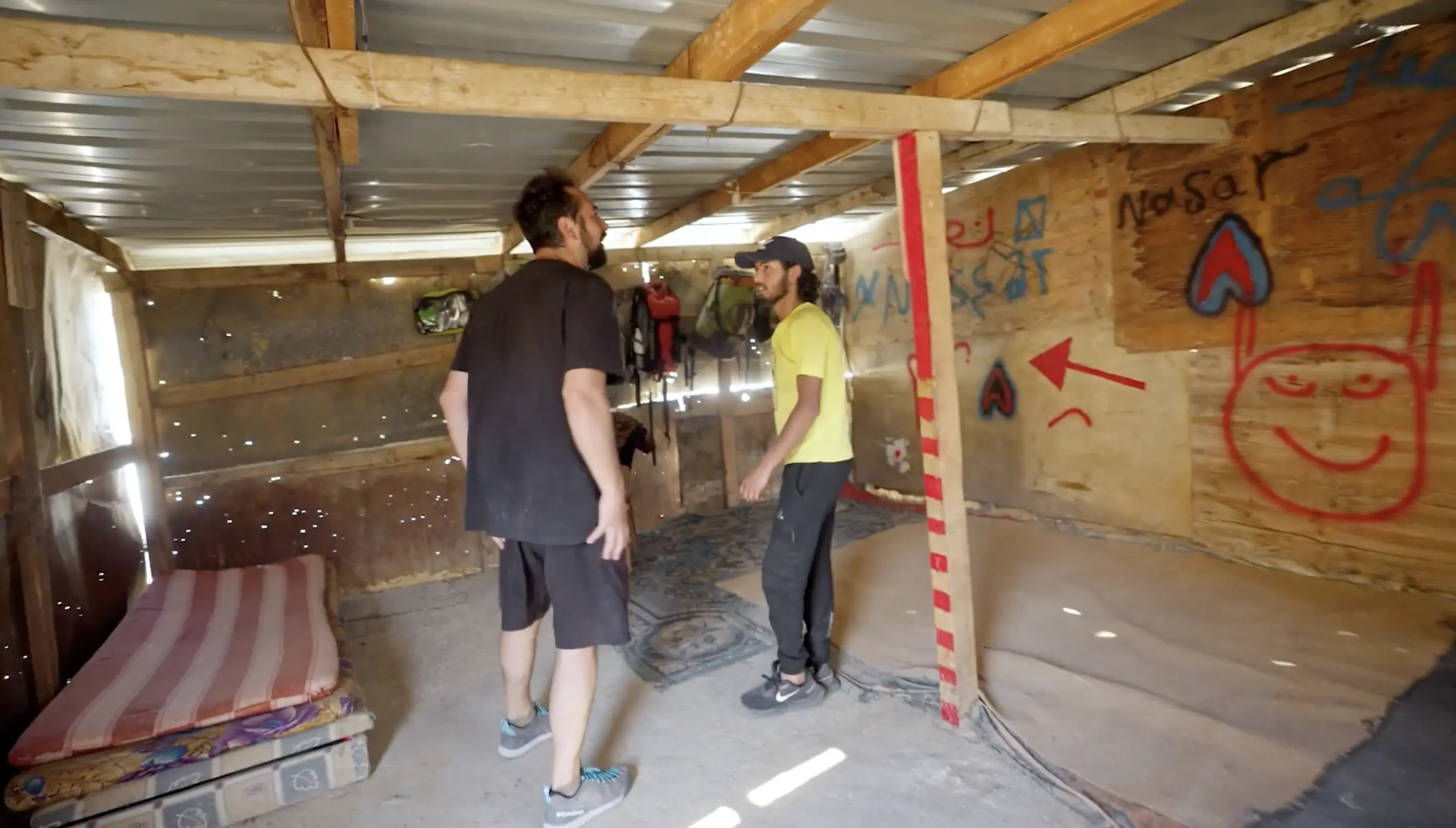 bisharat and tawfiq stand in tawfiq's shack home