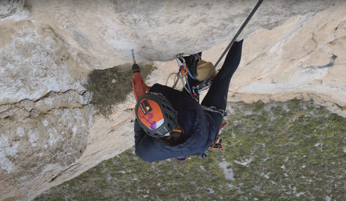 a climber drilling a bolt hole