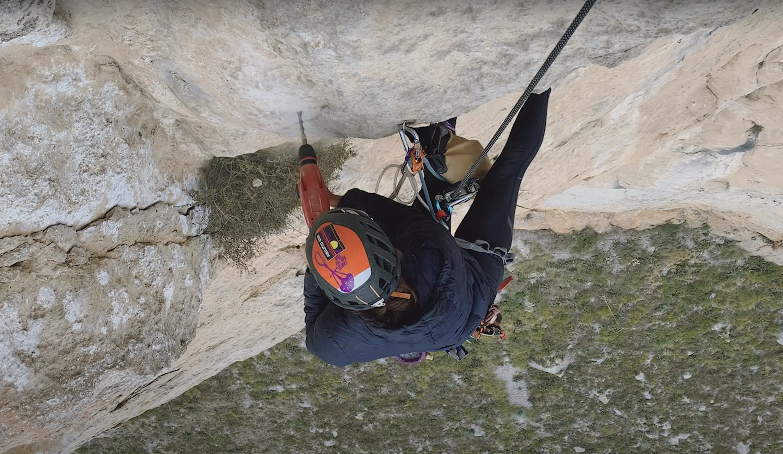 a climber drilling a bolt hole