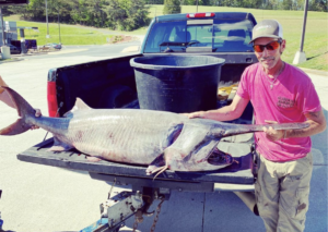 angler henry dyer with his tennessee state record paddlefish