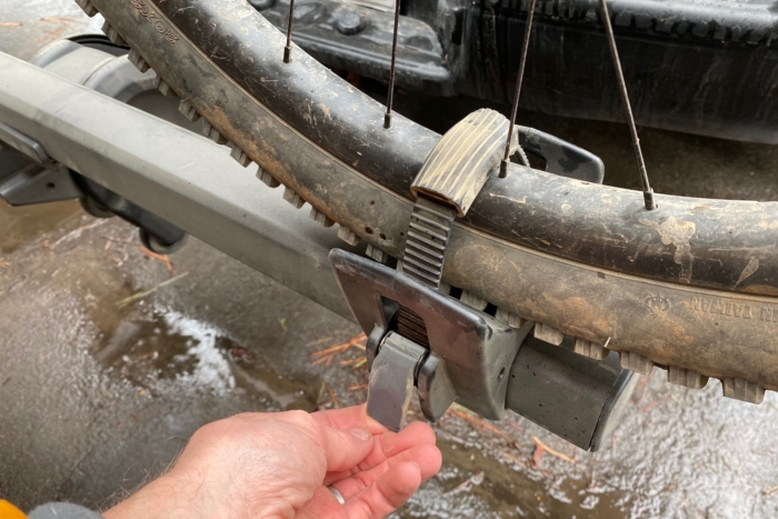 Tightening the racthet strap on the rear wheel of a bike on the Thule T2 Pro XTR rack