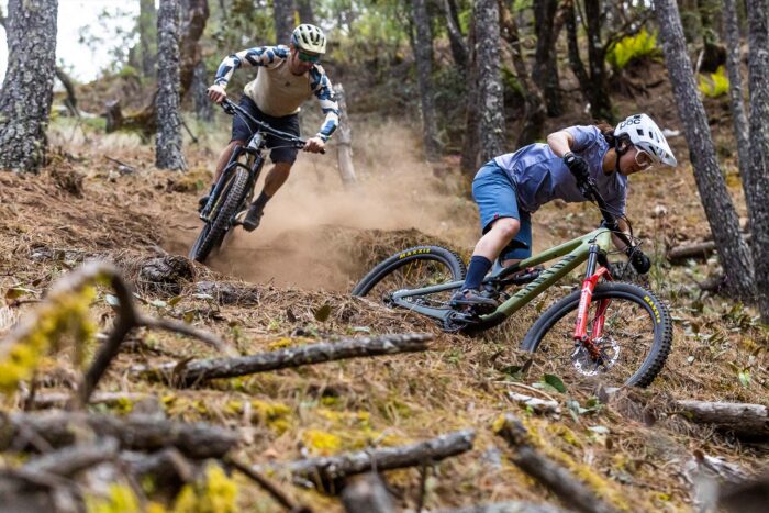 Two mountain bike riders ride downhill 