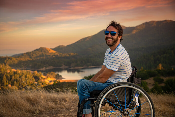 man in wheelchair on a sunset hike in the mountains