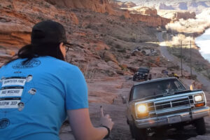 a woman directs a dodge ram charger up a steep hill