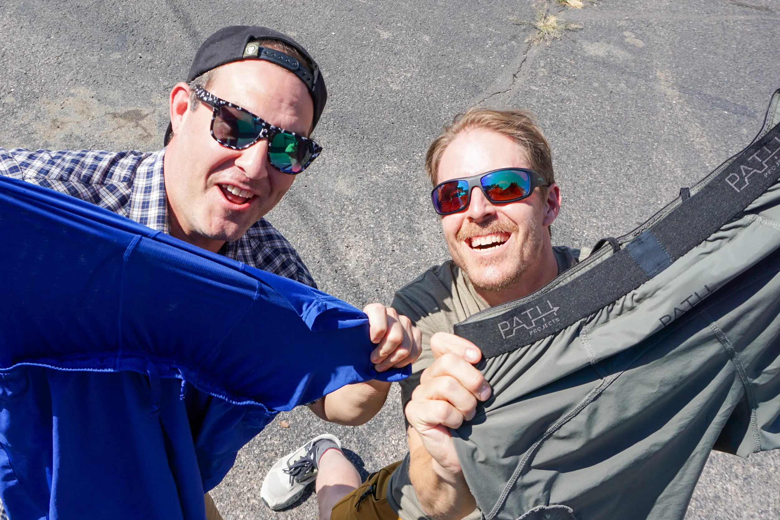 two men holding up running shorts
