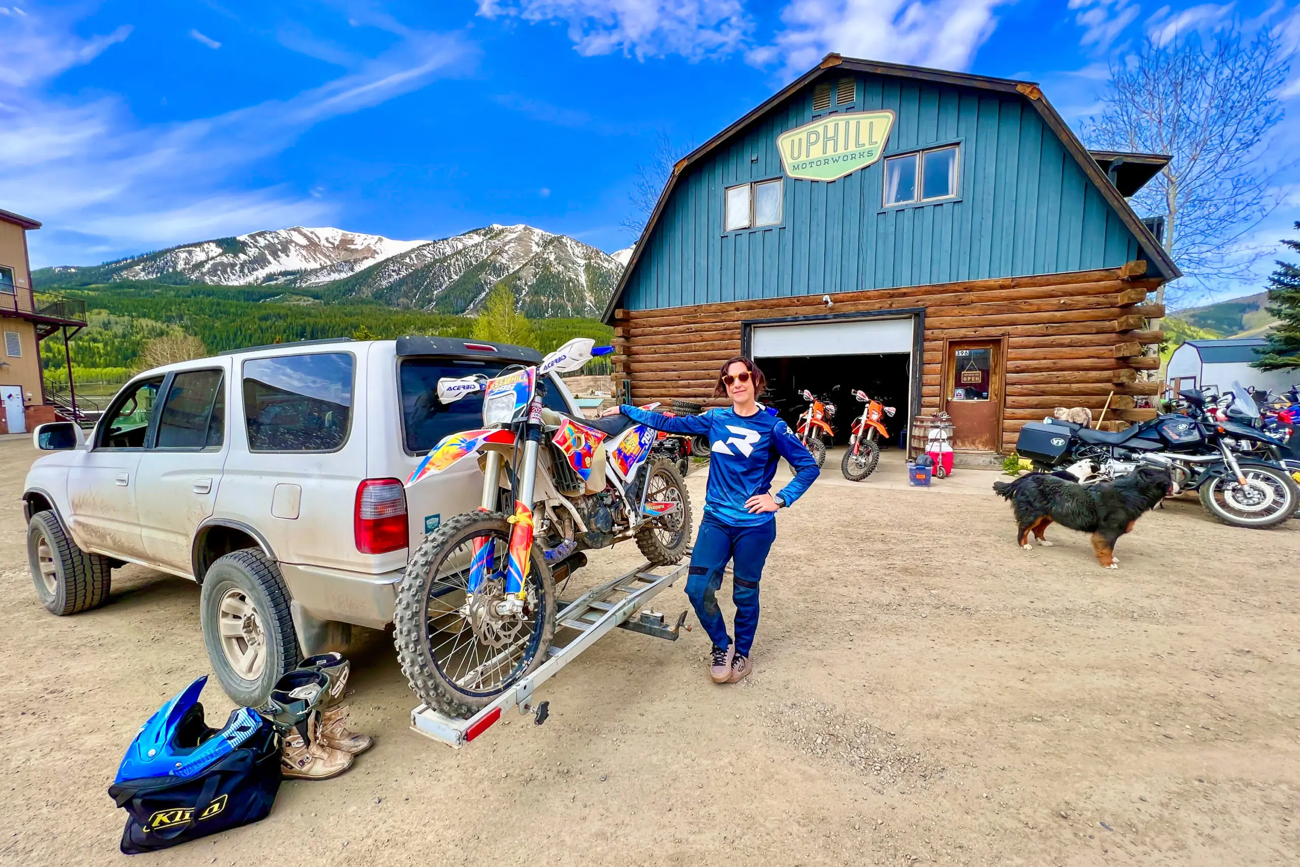 Co-owner of Uphill Motorworks Jesse Hill loading her dirt bike on a hitch carrier
