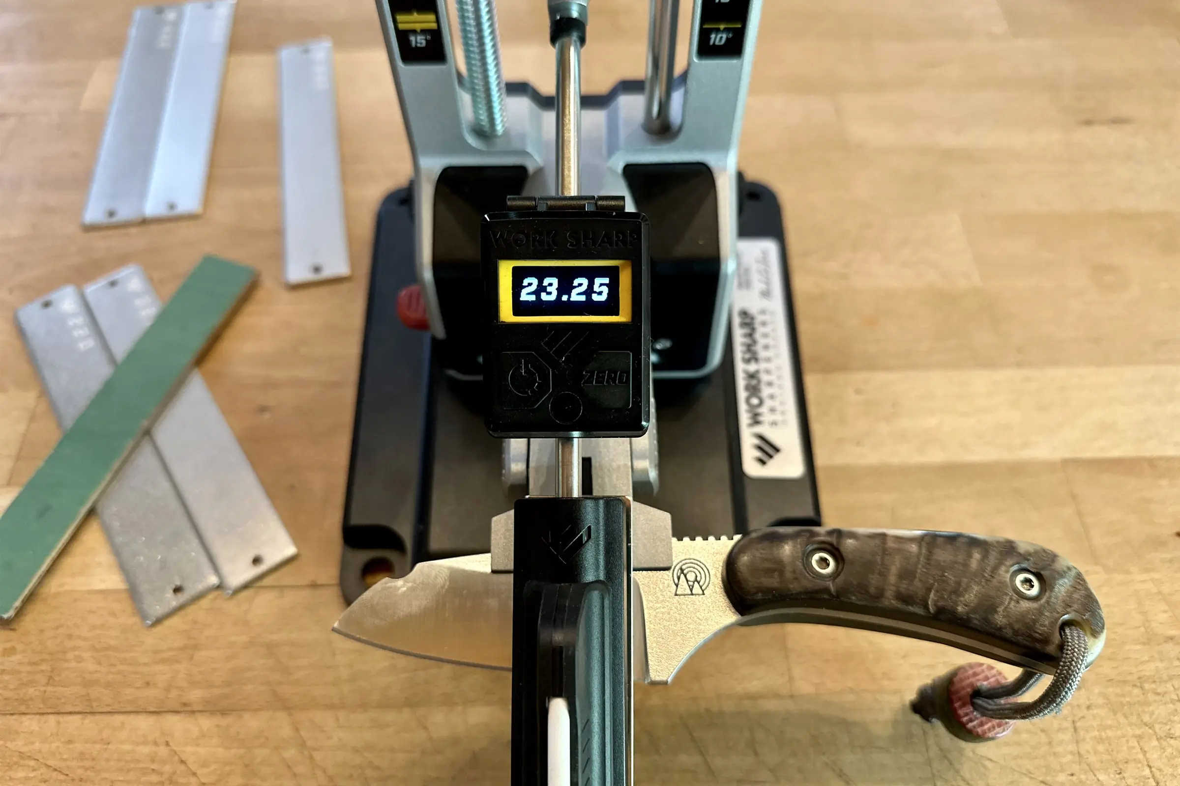 an angle gauge on a work sharp sharpener reads out 23.25 degrees while sharpening a small blade