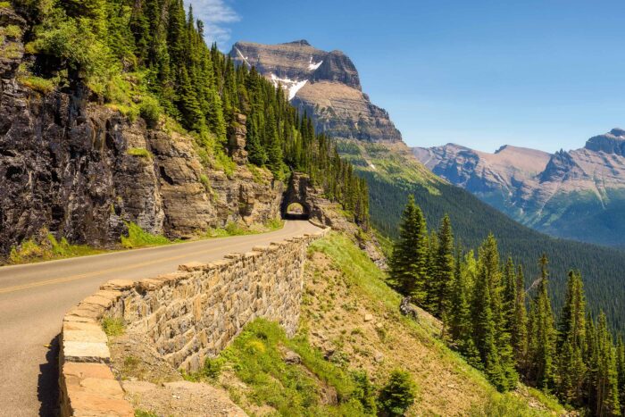 a road winds through a tunnel with mountains in the background 