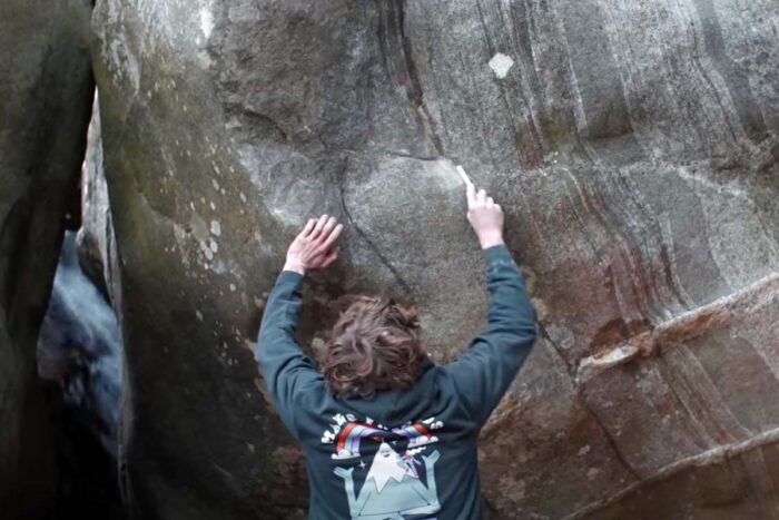 climber cleans boulder