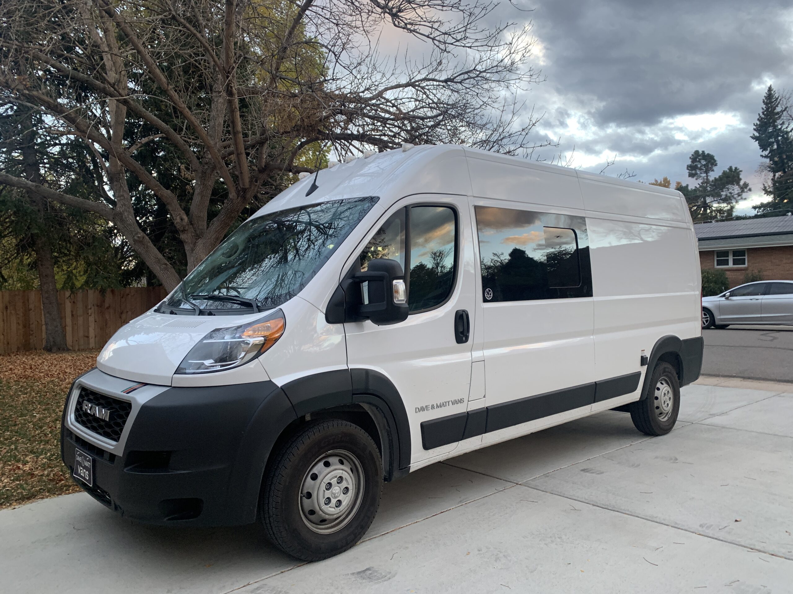 a dave and matt lv5.2 ram promaster van parked in a driveway