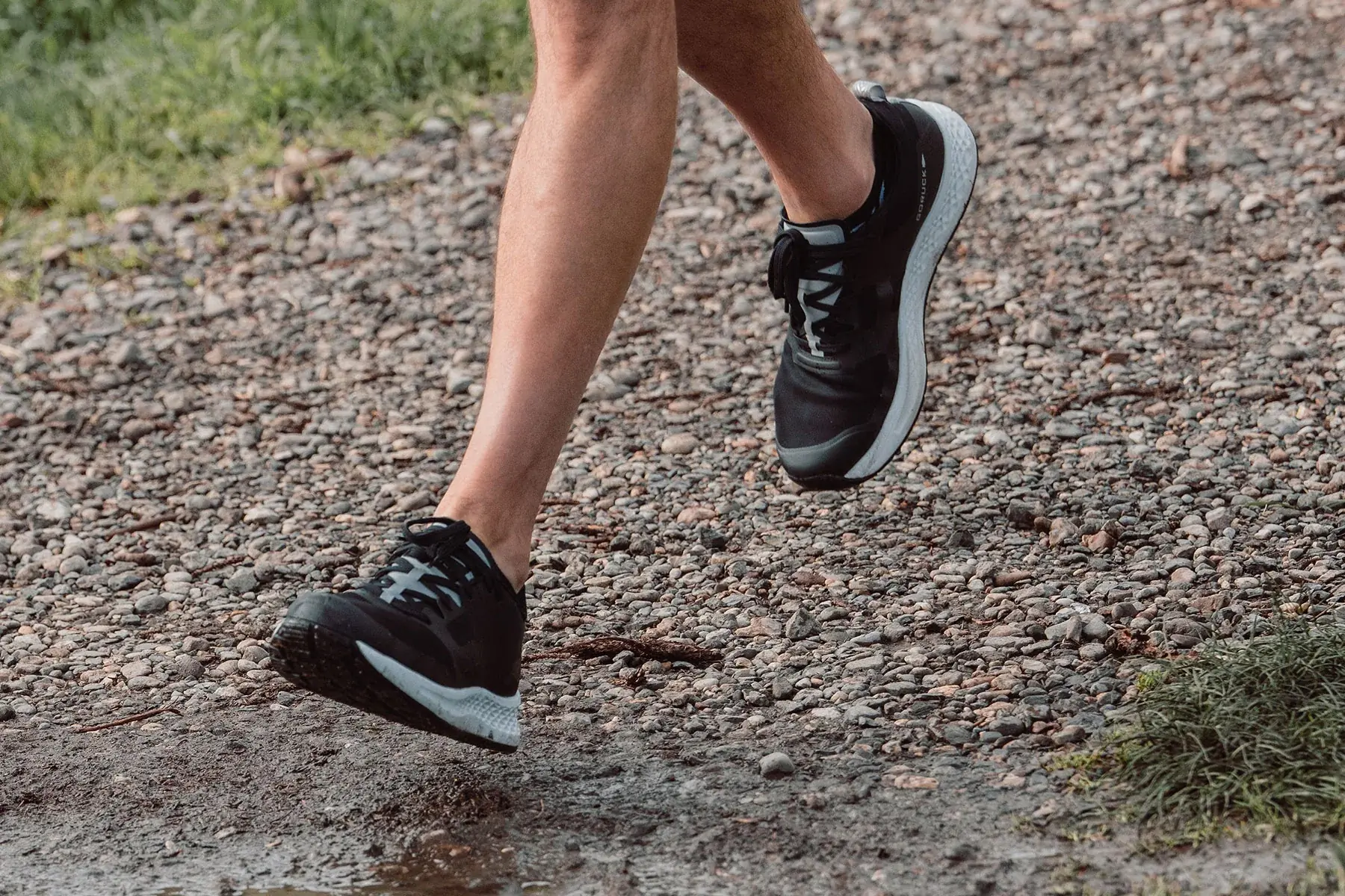 runner wearing goruck rough runner shoes on gravel trail