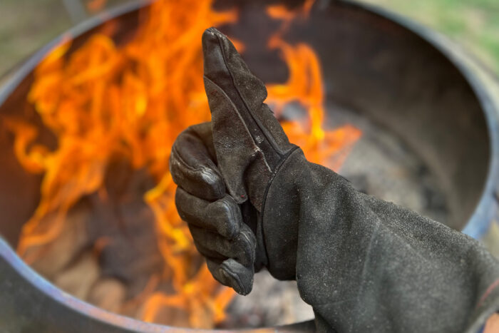 welding glove giving thumbs up over a fire