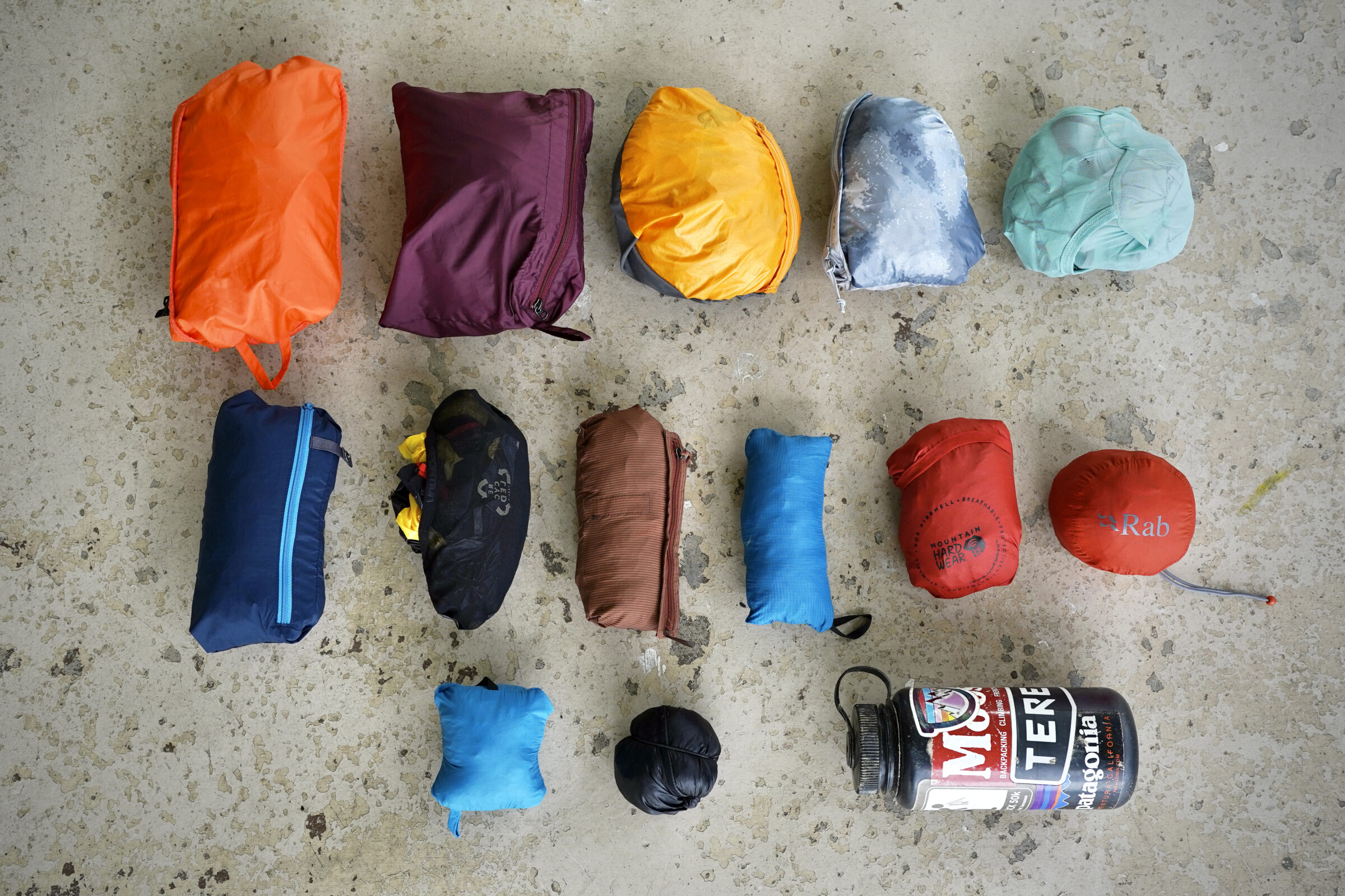 Windbreaker jackets lined up next to each other in their stuff sacks