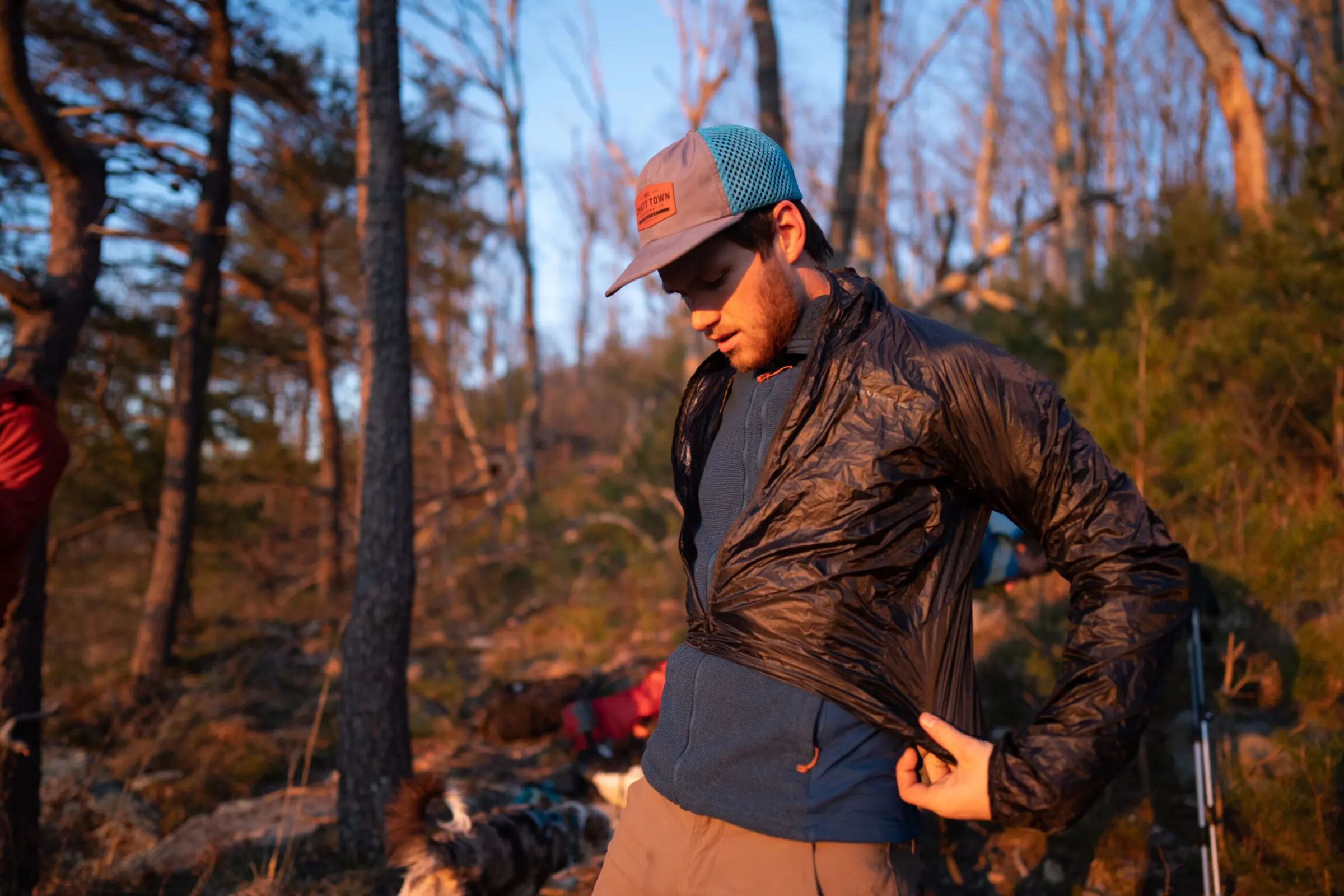 Man puts a lightweight windbreaker jacket on