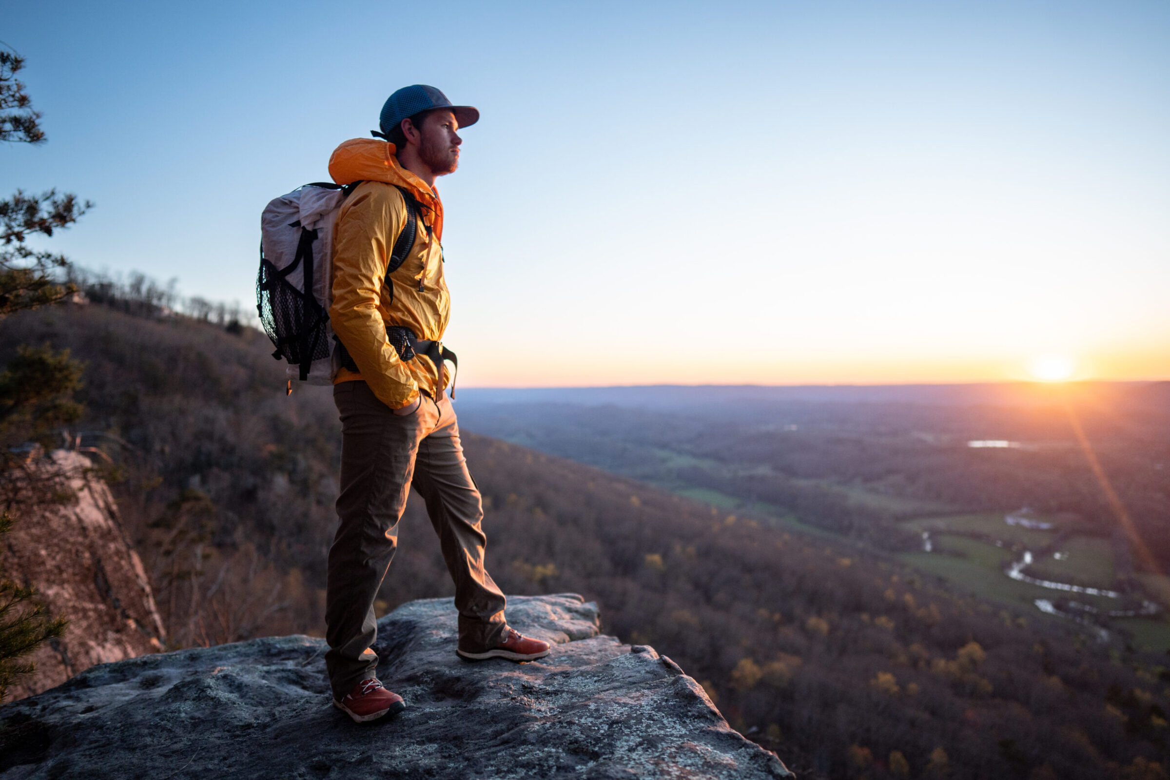 Man wears the Outdoor Research Helium on top of a mountain while hiking
