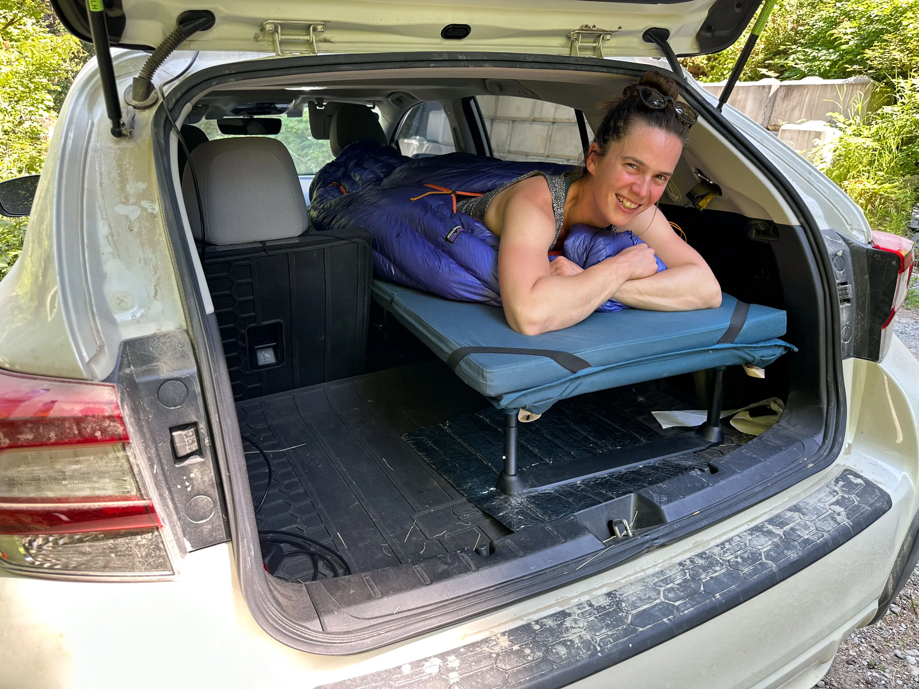 Female Tester Lays on the REI Co-op Trailgate Vehicle Cot in Subaru Crosstrek