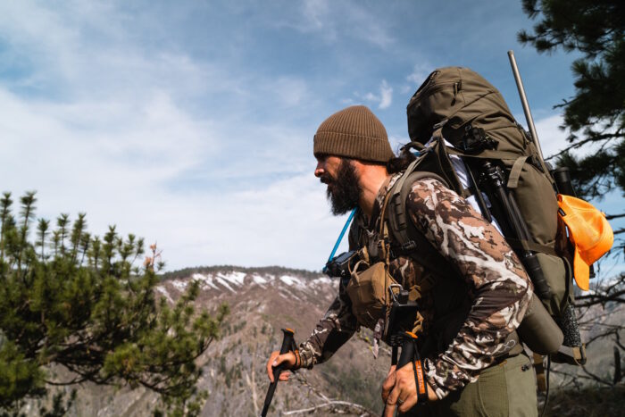 Hunter with a backpack and hunting rifle