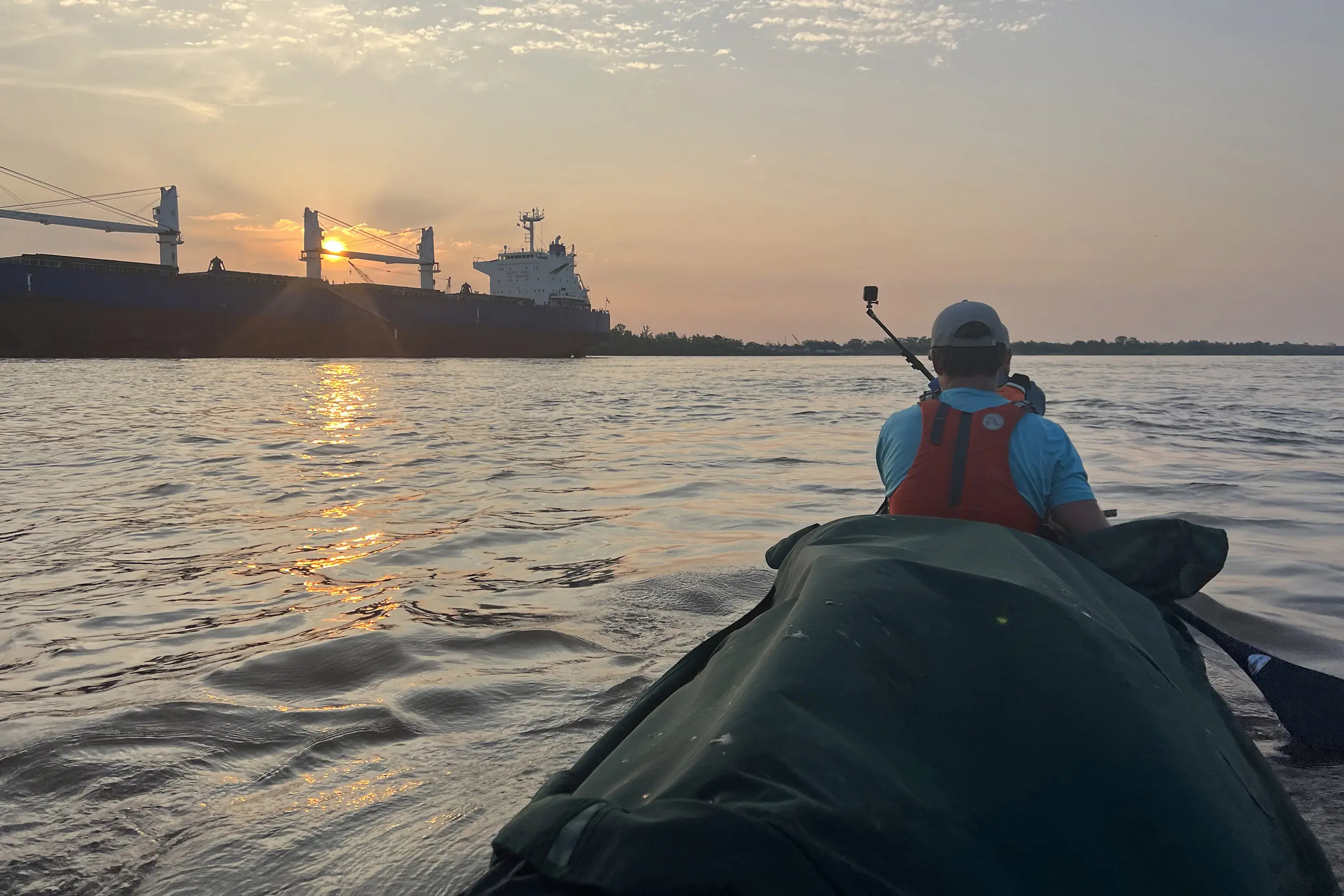 a view of a large ship passing a canoe