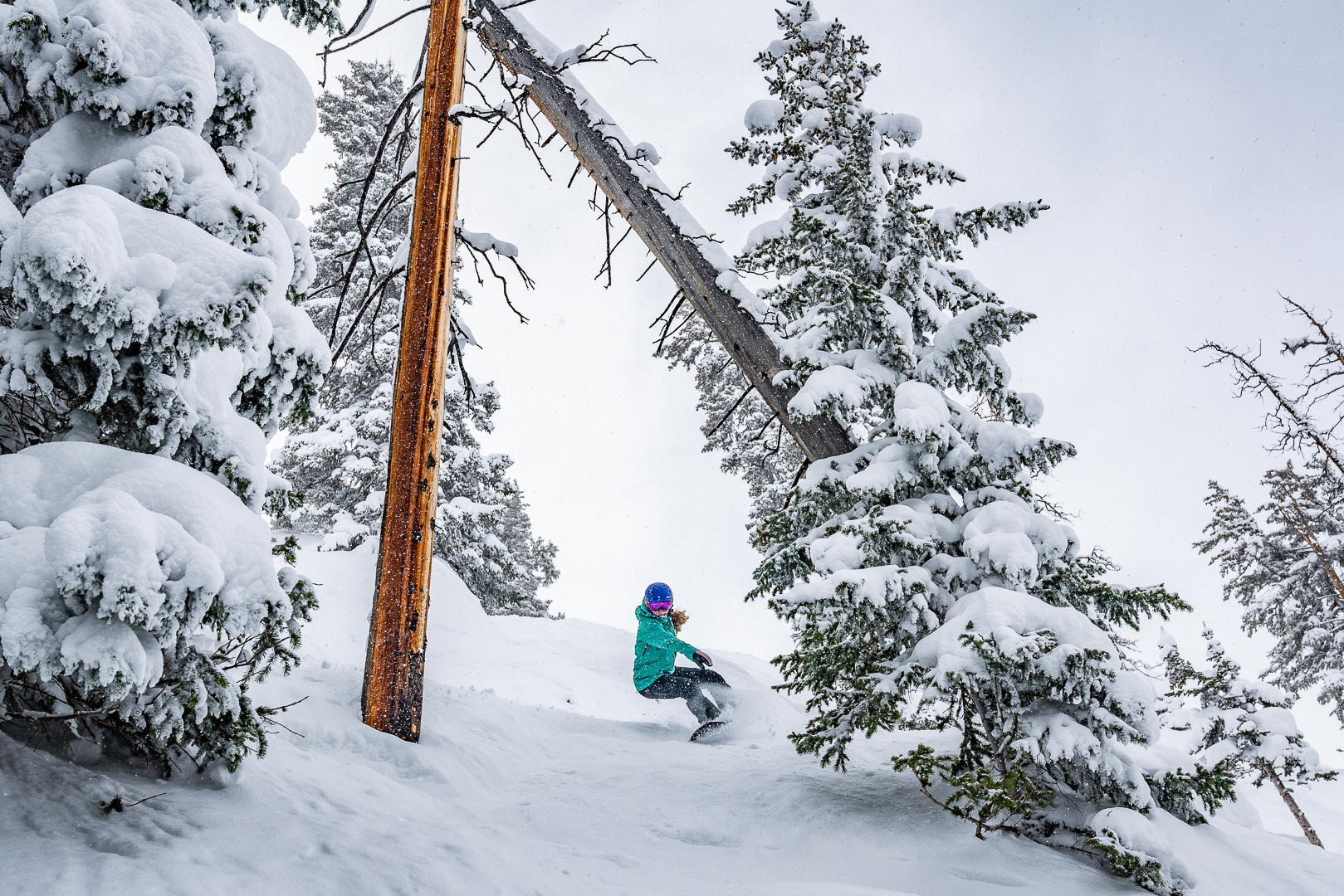 woman riding Stranda descender snowboard through trees
