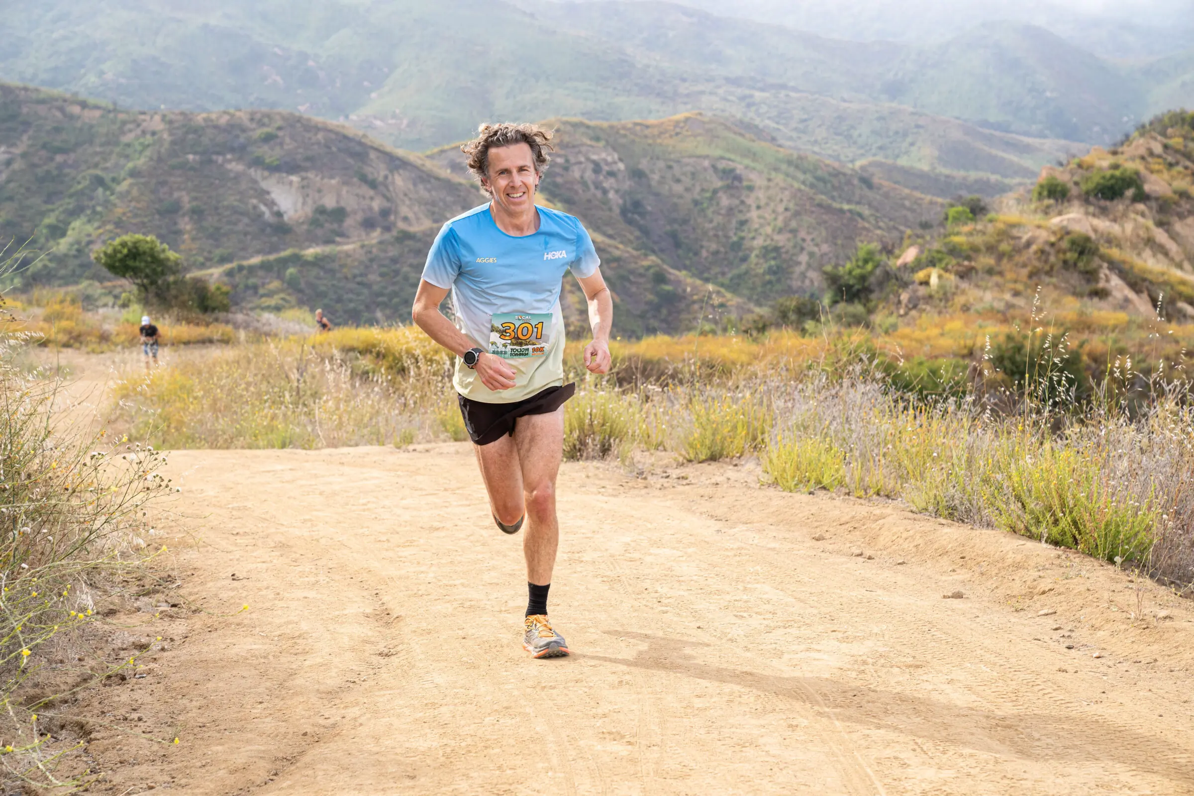Man runs up a hill while wearing running shorts