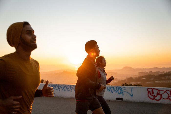 three people running outside at sunset for rei sale labor day